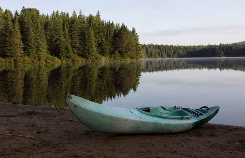 An empty kayak by a lake